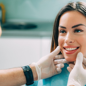 A dentist assessing a woman for cosmetic dentistry