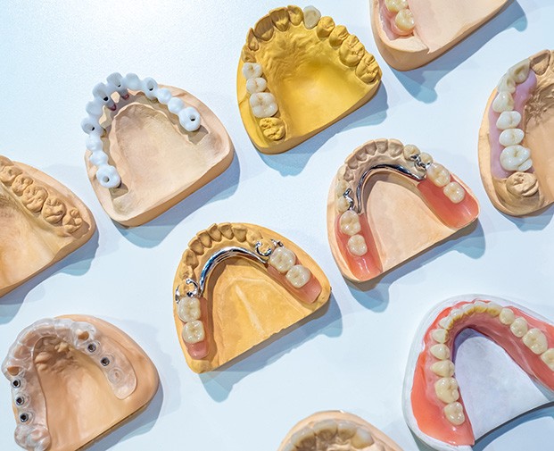 Various types of dentures against a blue background