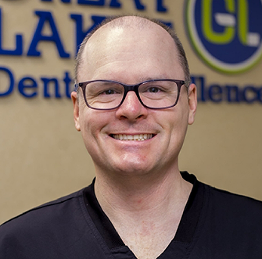 Man in dental chair smiling up at his dentist in New Baltimore